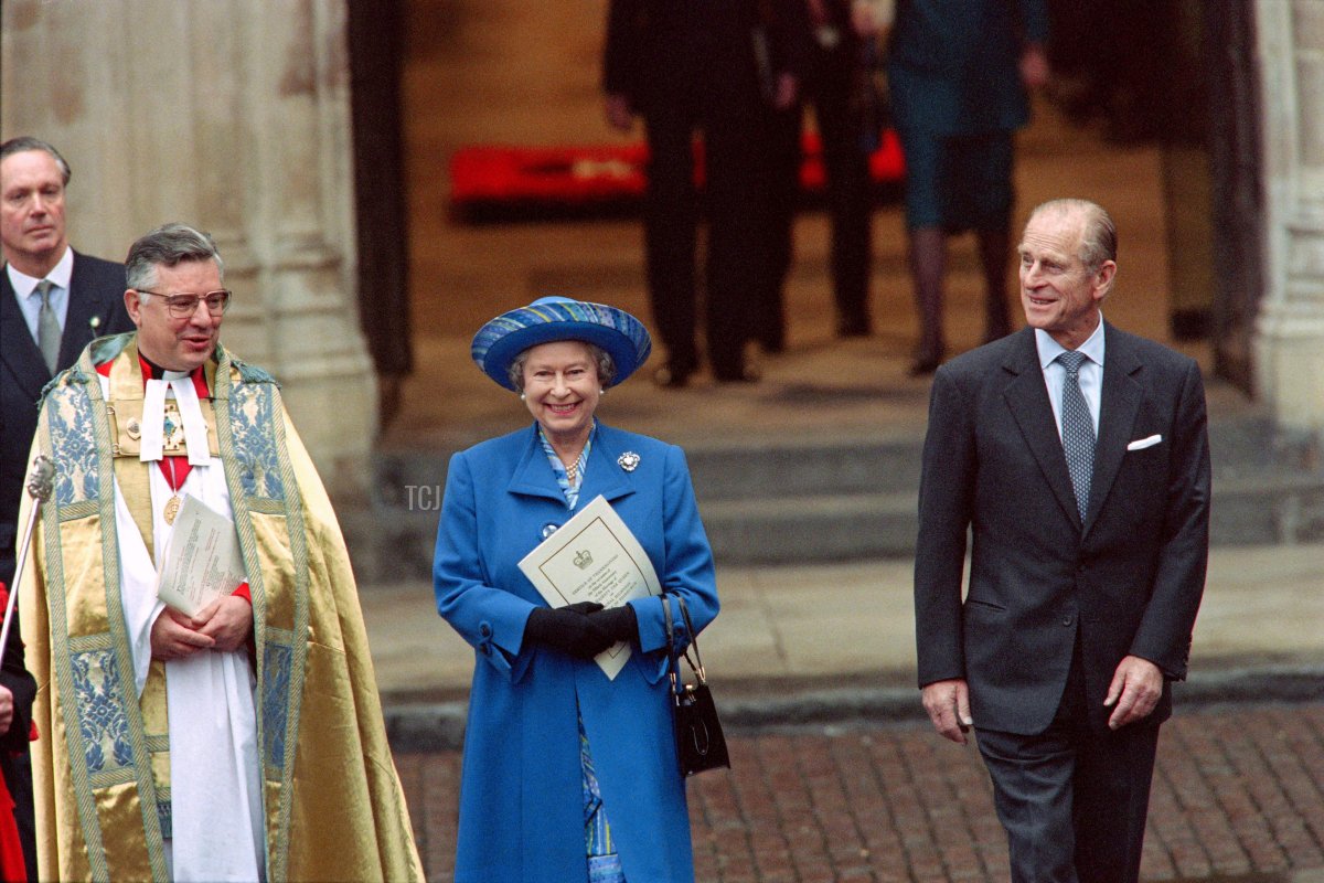 Britain's Queen Elizabeth II (C) and Prince Philip (R) in jovial mood after thanking the Dean of Westminster (L) for a special service at Westminster Abbey to celebrate their 50th Wedding Aniversary, leave the Westminster Abbey on November 20, 1997
