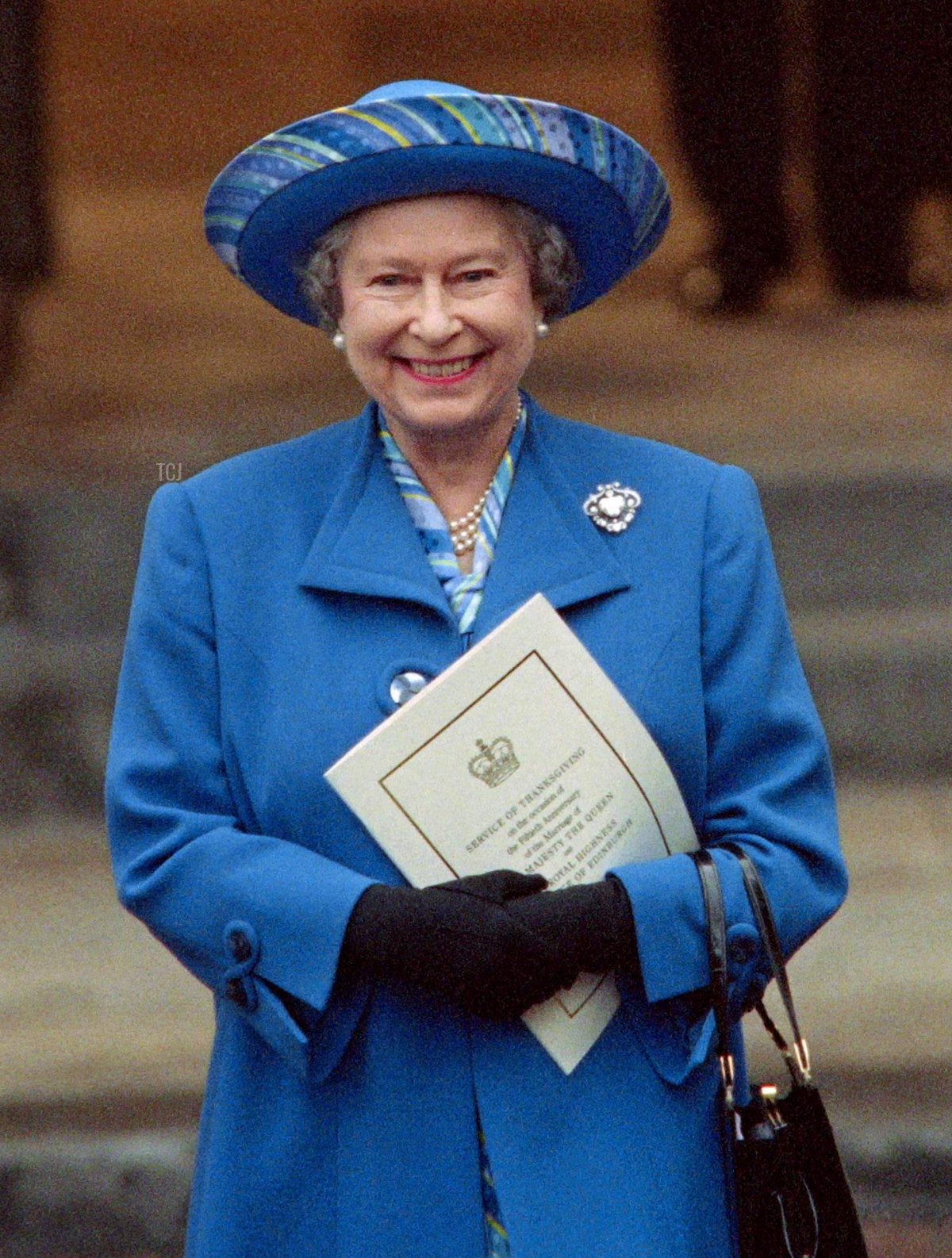 Britain's Queen Elizabeth II (C) and Prince Philip (R) in jovial mood after thanking the Dean of Westminster (L) for a special service at Westminster Abbey to celebrate their 50th Wedding Aniversary, leave the Westminster Abbey on November 20, 1997