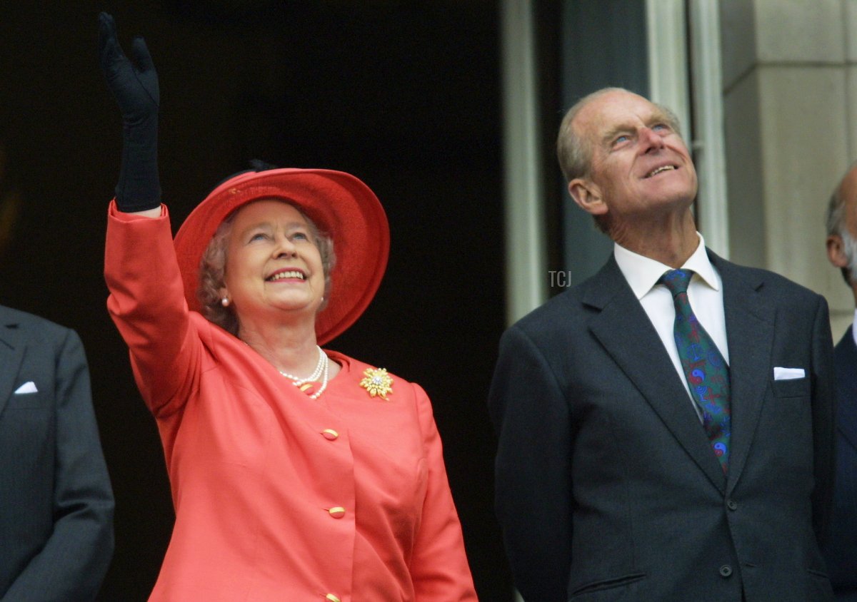 Queen Elizabeth II and Prince Philip look up from the balcony of Buckingham Palace as Concorde flies past during the Golden Jubilee celebrations in London 04 June 2002