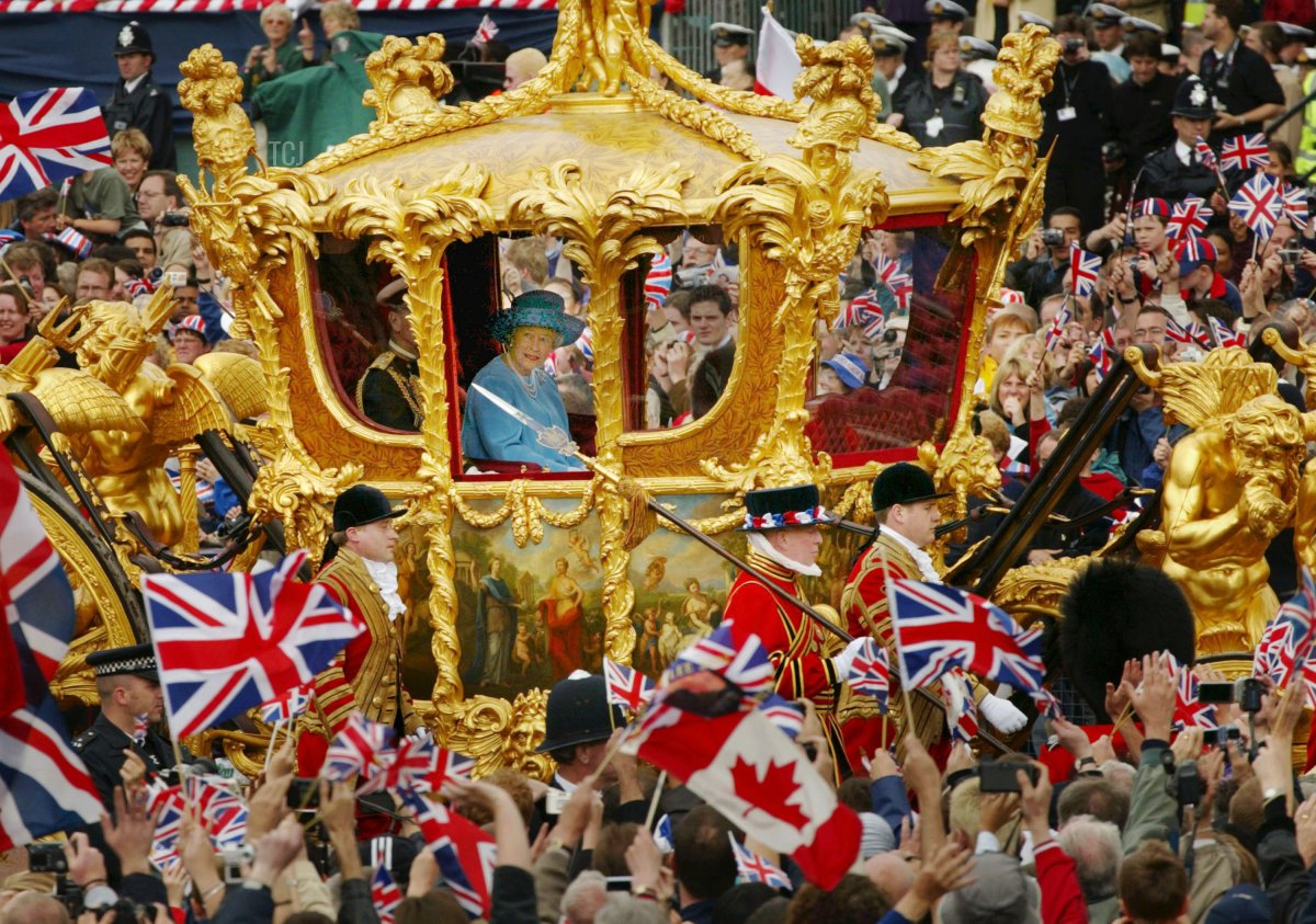 Britain's Queen Elizabeth and Prince Philip ride in the Golden State Carriage at the head of a parade from Buckingham Palace to St Paul's Cathedral celebrating the Queen's Golden Jubilee June 4, 2002 along The Mall in London