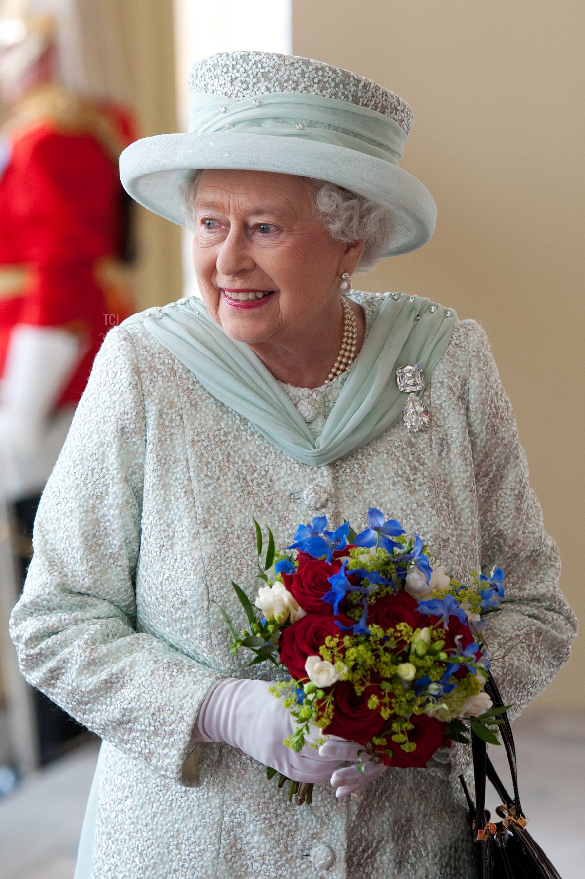 Britain's Queen Elizabeth II holds a bouquet of flowers as she returns to Buckingham Palace after attending a National Service of Thanksgiving and a Lunch in honour of the diamond jubilee in London, on June 5, 2012
