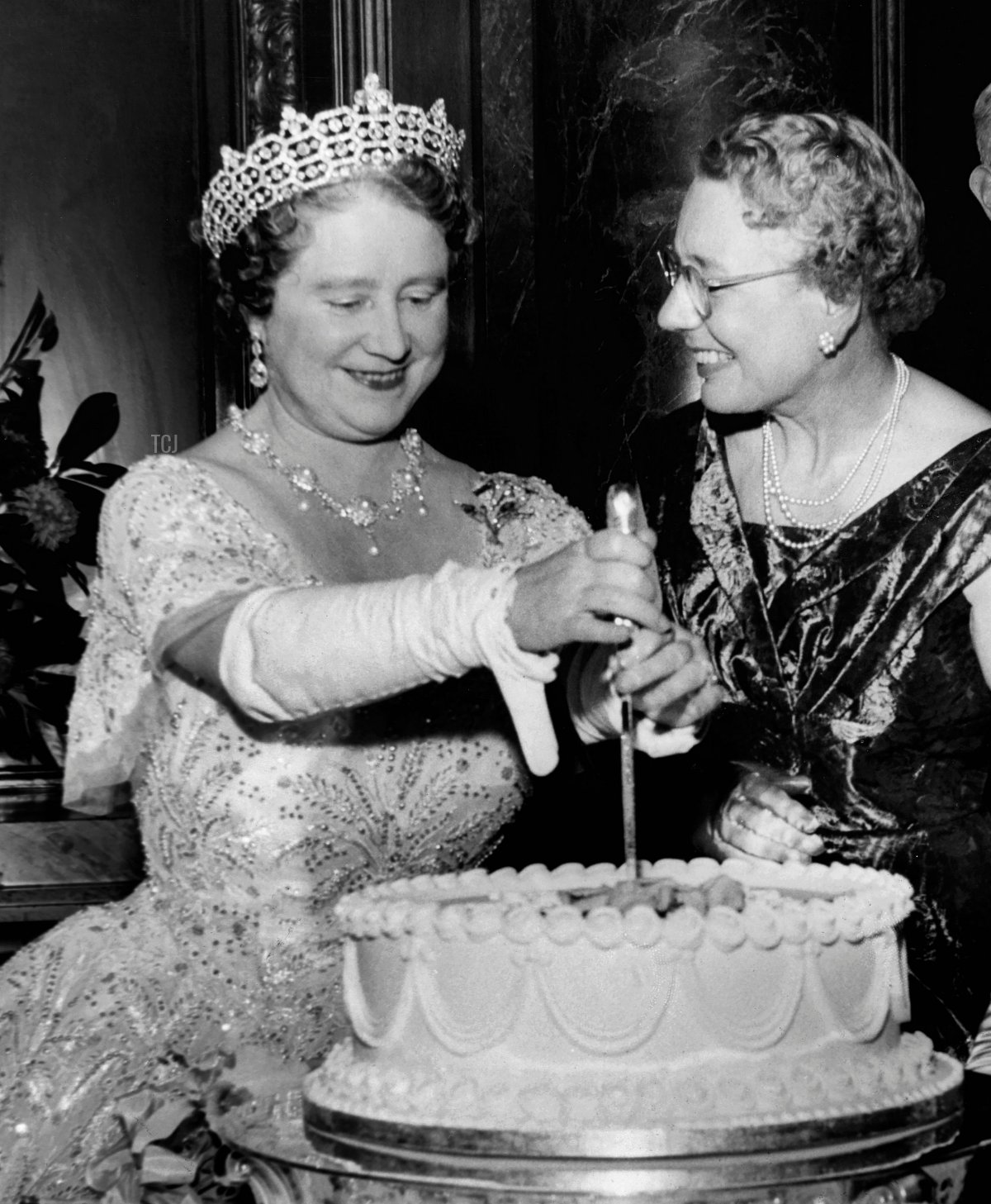 Picture taken on November 26, 1960 at London showing Queen Elizabeth, the Queen Mother (L), cutting the birthday cake of the Women's Group