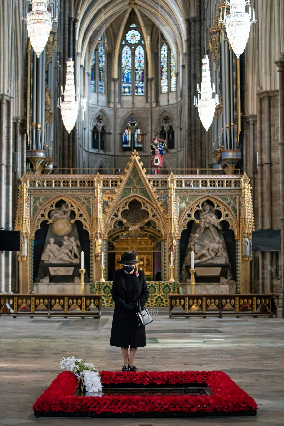 Britain's Queen Elizabeth II looks on after her Equerry, Lieutenant Colonel Nana Kofi Twumasi-Ankrah placed a bouquet of flowers at the grave of the Unknown Warrior to mark the centenary of the burial of the Unknown Warrior ahead of Remembrance Sunday at Westminster Abbey in London on November 4, 2020