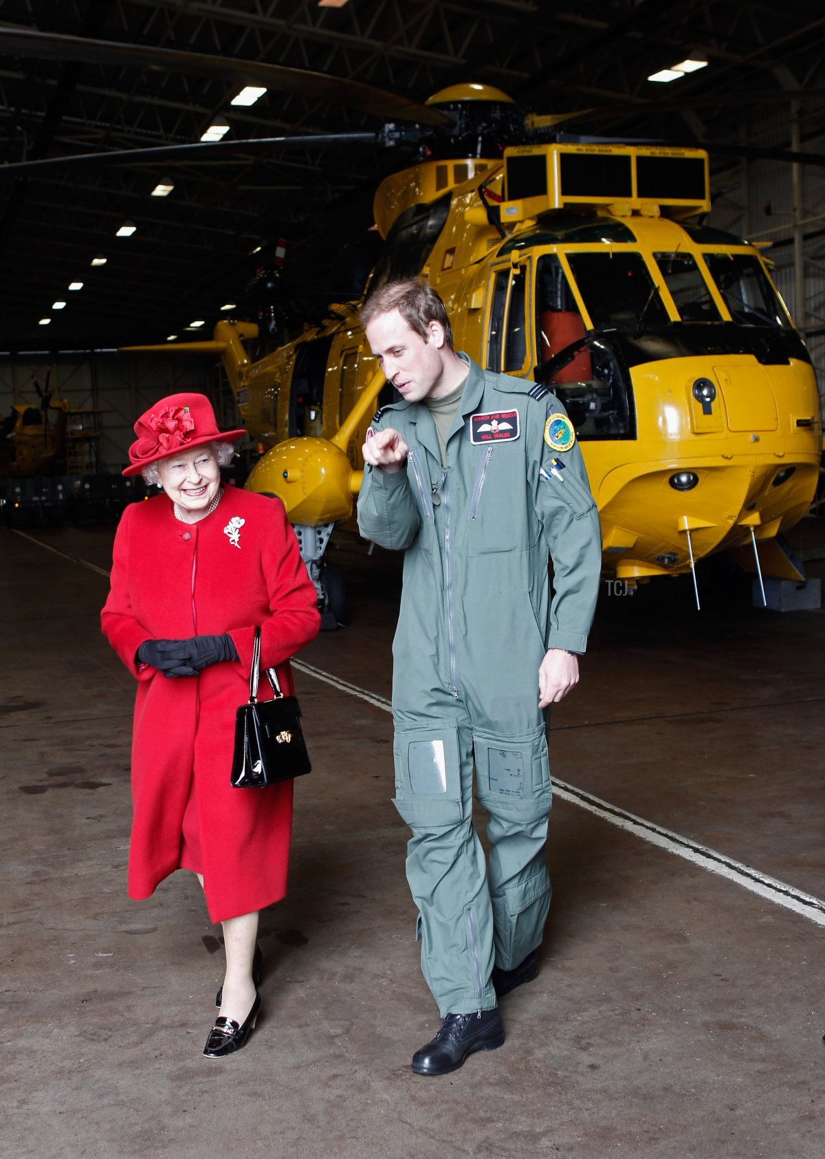 Queen Elizabeth II is escorted by her grandson Prince William during a visit to RAF Valley where Prince William is stationed as a search and rescue helicopter pilot on April 1, 2011 in Holyhead, United Kingdom