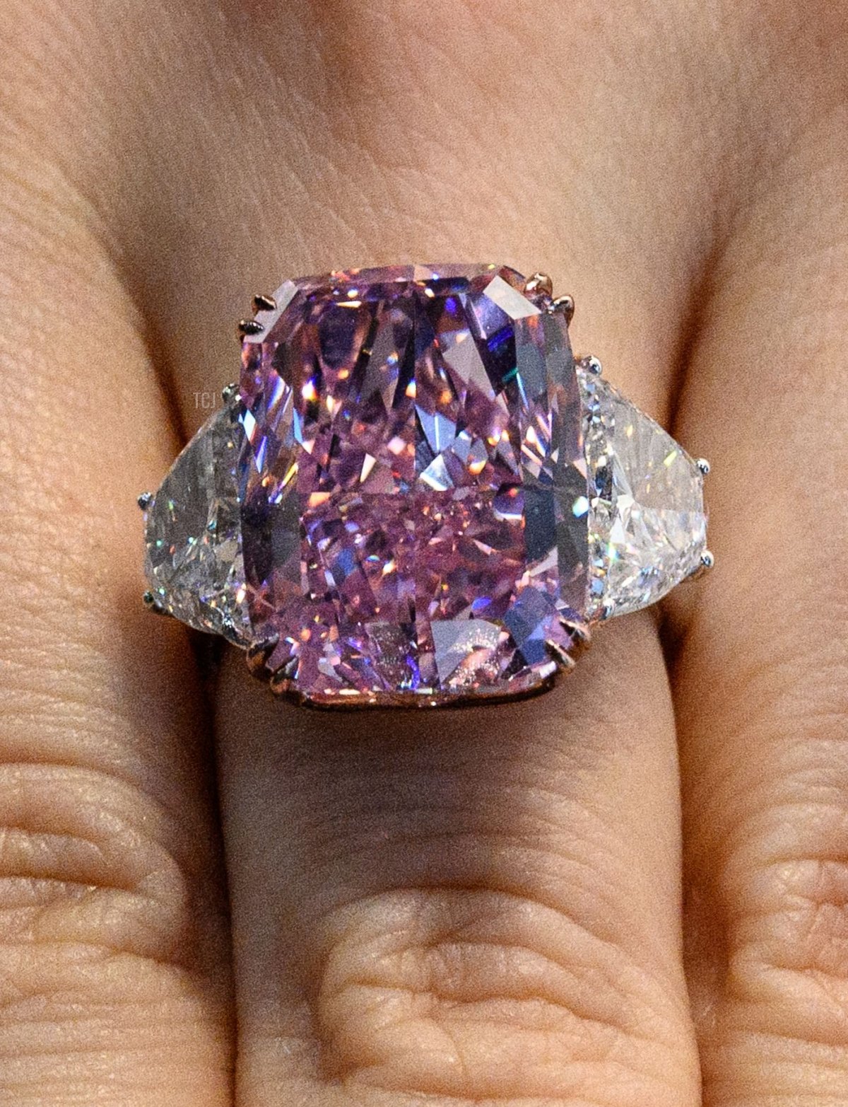A woman displays the Sakura Diamond, a 15.81 Carat fancy vivid purple pink Internally flawless type lla diamond ring, during a Christies pre-auction preview in Hong Kong on May 20, 2021