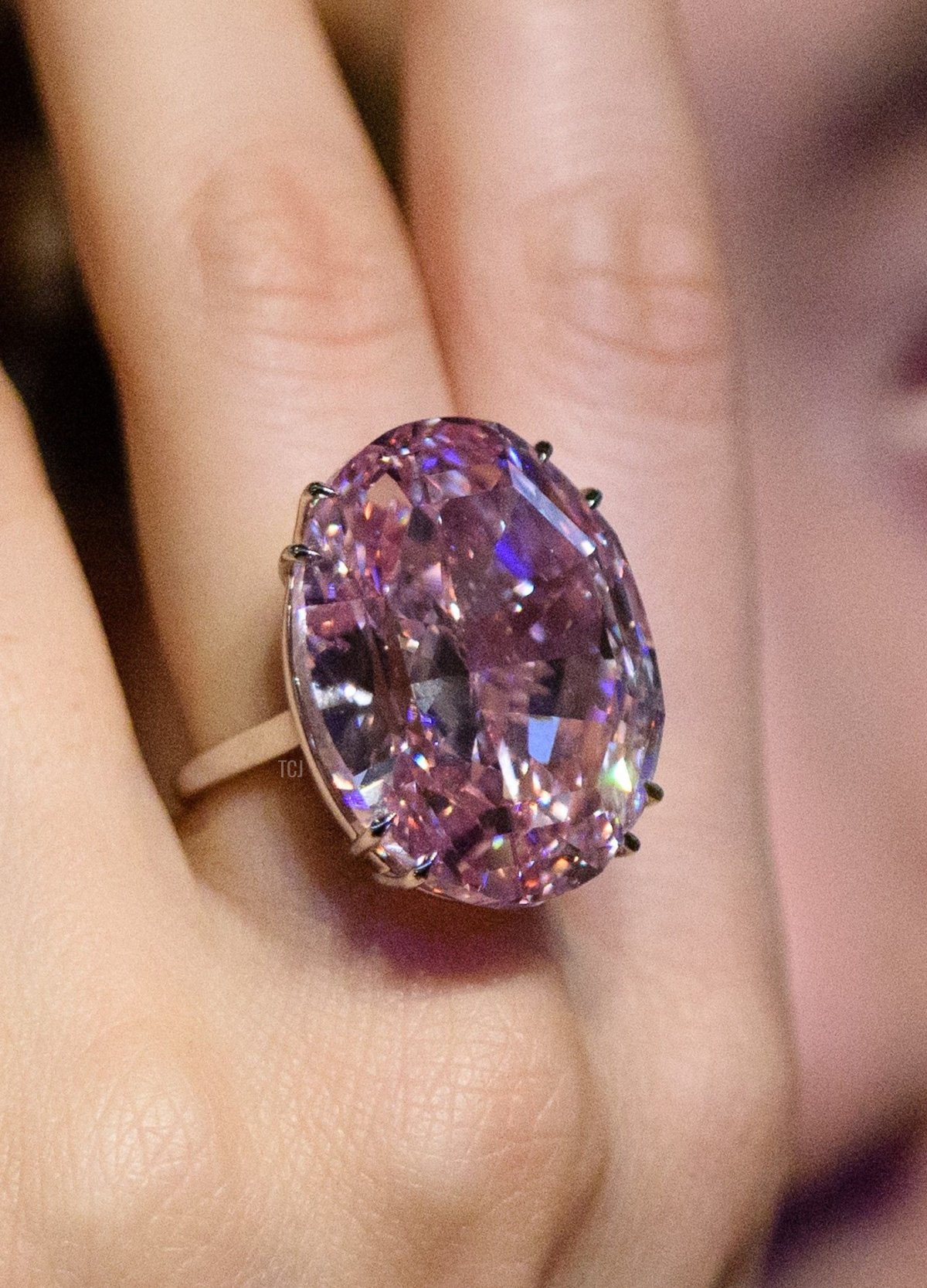 A model poses with a 59.60-carat oval mixed-cut pink diamond, known as 'The Pink Star', during a Sotheby's media preview in Hong Kong on March29, 2017, to promote its auction on April 4