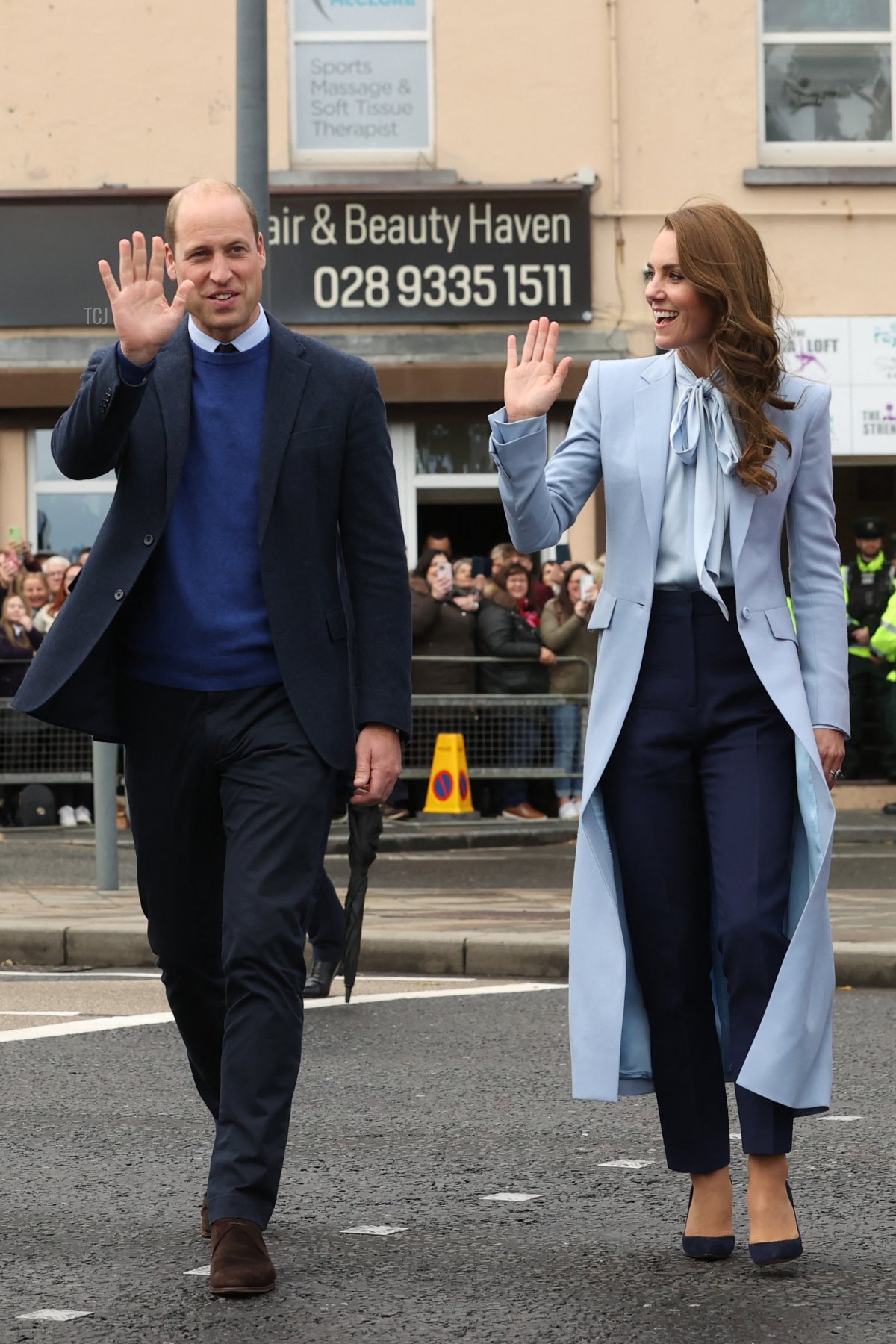 Britain's Prince William, Prince of Wales (L) and Britain's Catherine, Princess of Wales (R) wave to members of the public during a walkabout in Carrickfergus, as part of a visit to Northern Ireland, on October 6, 2022