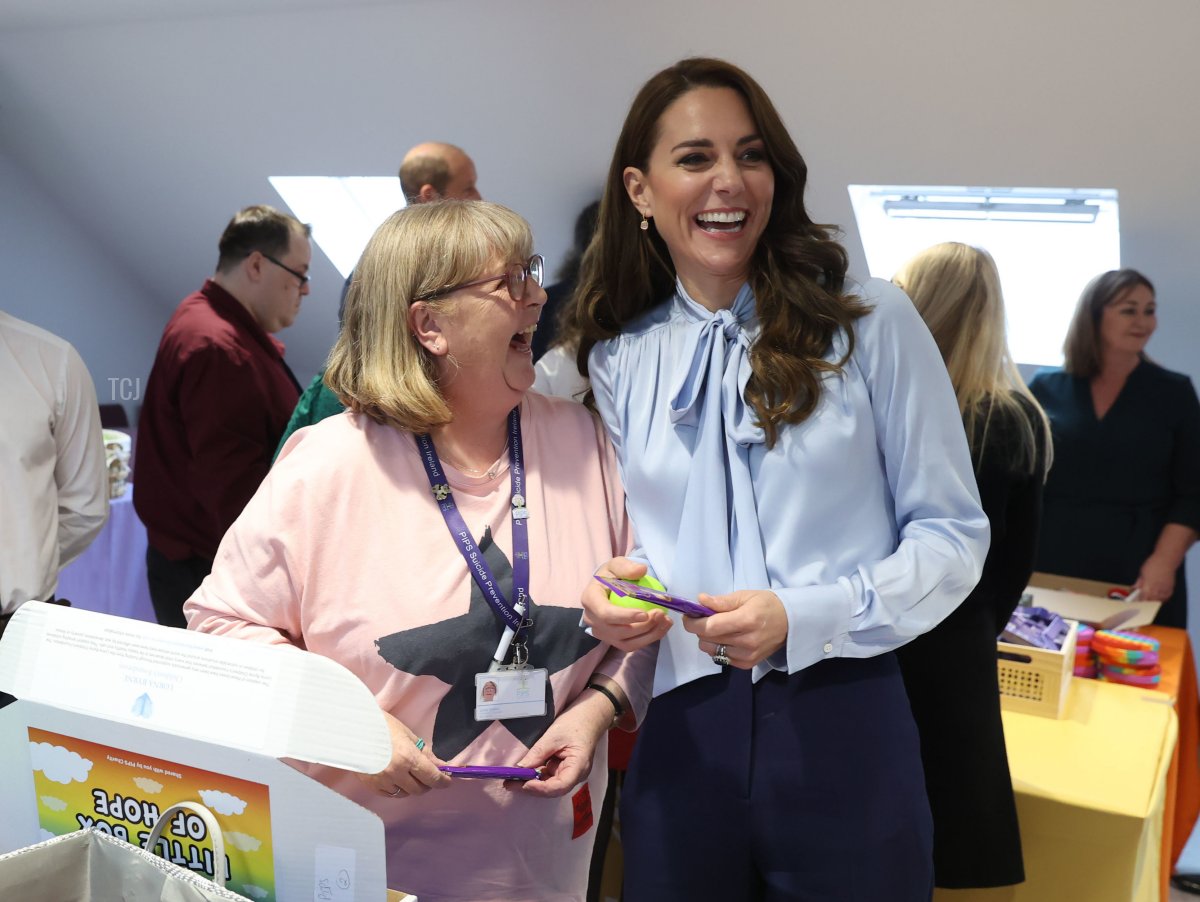 Catherine, Princess of Wales laughs with a volunteer during a visit to PIPS Suicide Prevention (PIPS Charity) in Belfast which works across communities in the city and throughout Northern Ireland to provide crisis support for those at risk of suicide and self-harm, as part of the royal visit to Northern Ireland on October 6, 2022 in Belfast, Northern Ireland