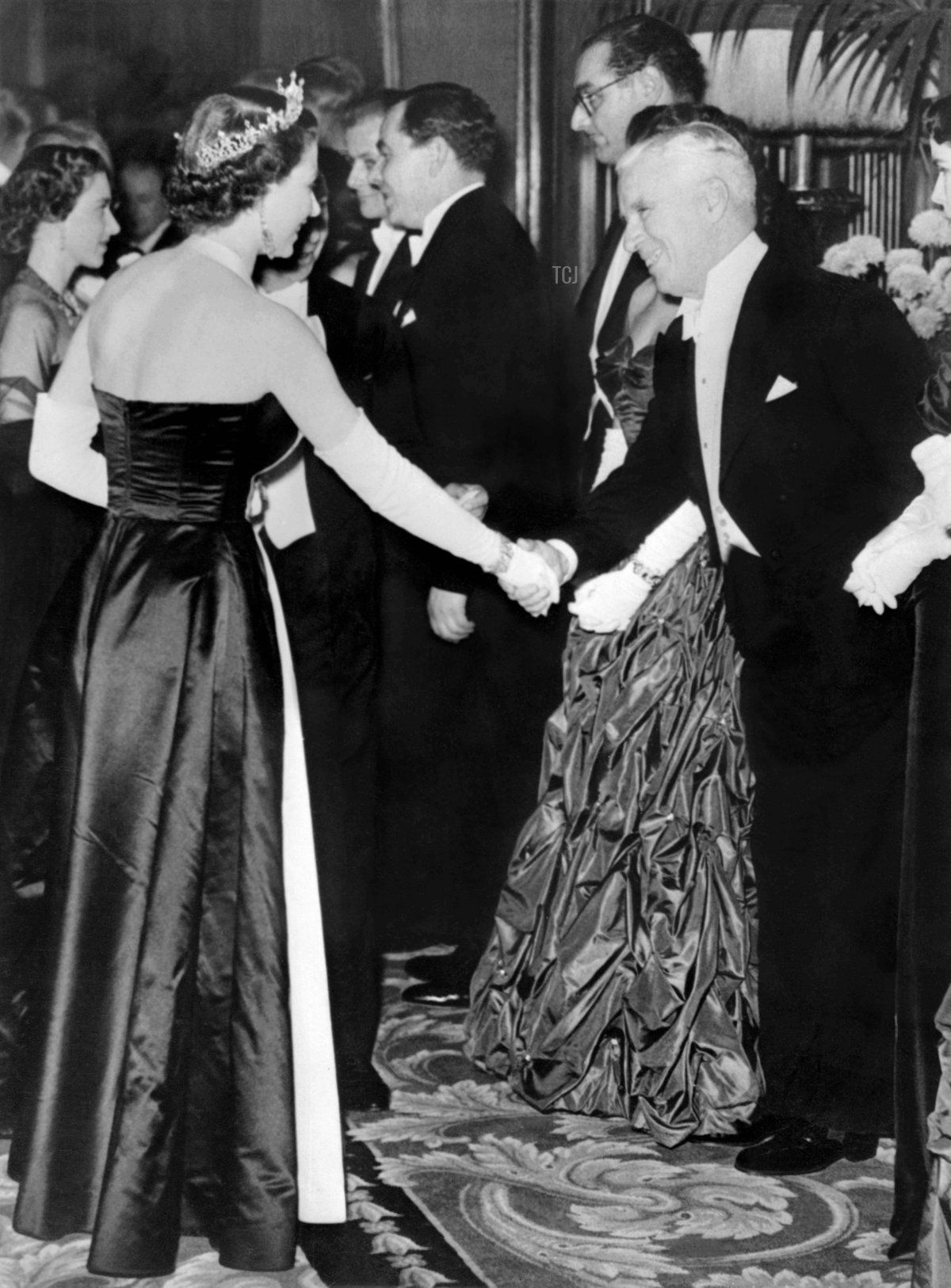 British actor Charlie Chaplin shakes hand with Britain's Queen Elizabeth II on October 27, 1952
