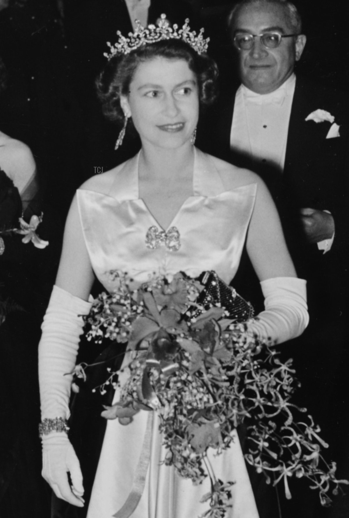 Queen Elizabeth II is escorted by Reginald Bromhead, the Chairman of the Cinematograph and Trade Benevolent Fund, as she and Princess Margaret (behind) leave the Royal Film Performance in Leicester Square, London, October 27th 1952
