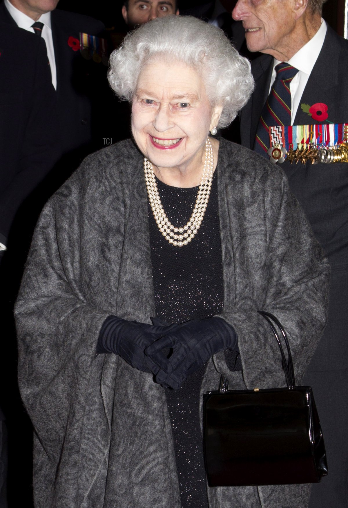 Britain's Queen Elizabeth II walks next to Vice President of the British Legion Vice Admiral Peter Wilkinson as she arrives at the annual Royal British Legion Festival of Remembrance at the Royal Albert Hall in London on November 9, 2013