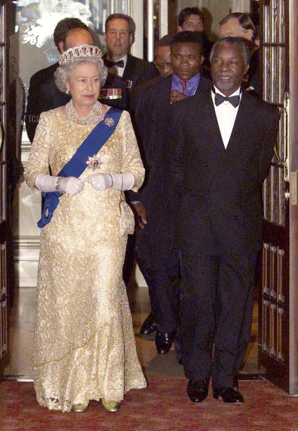 Britain's Queen Elizabeth II arrives with South African President Thabo Mbeki for a state banquet held for the Commonwealth Heads of Government, in Durban 12 November 1999