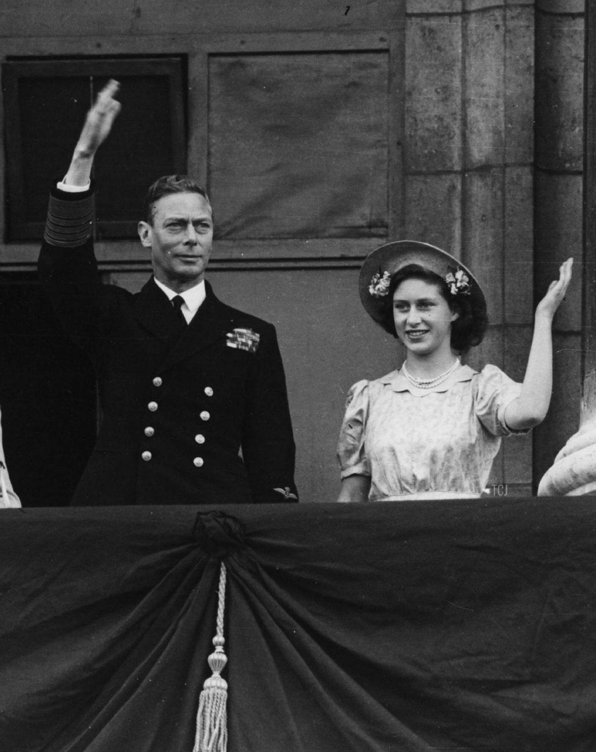 From left to right, Princess Elizabeth, Queen Elizabeth, King George VI, and Princess Margaret Rose wave from the balcony of Buckingham Palace August 15, 1945 on VJ Day in London, England