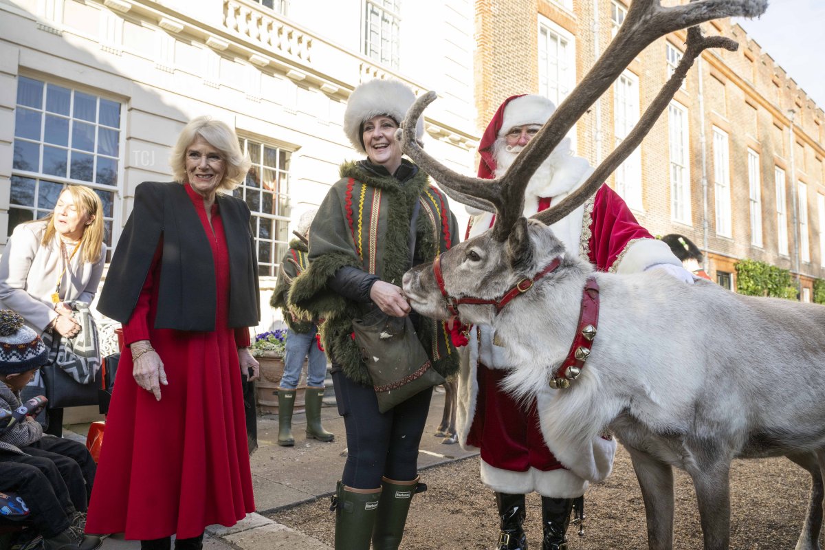 Her Majesty, Camilla, The Queen Consort meets Blixen the reindeer and Santa Claus at Clarence House on December 7, 2022, in London, England