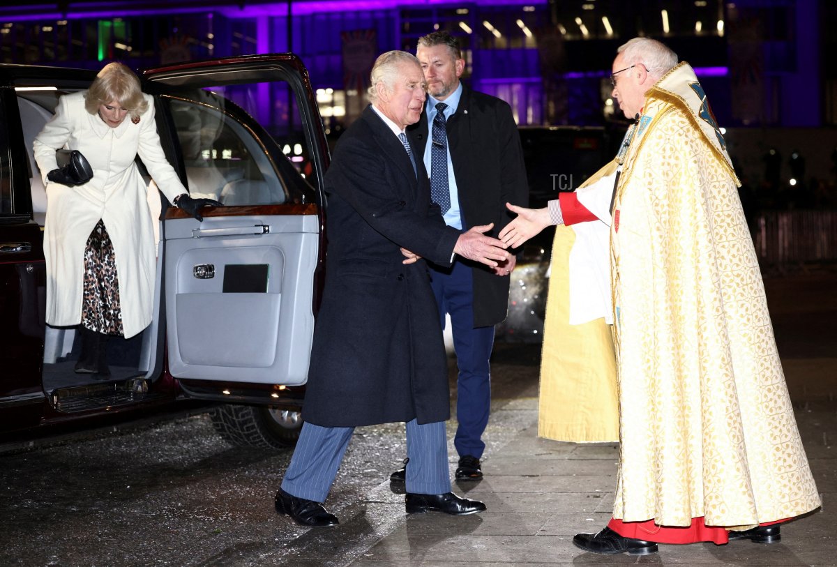 Britain's King Charles III (C) is welcomed by Dean of Westminster David Hoyle upon arrival with Britain's Camilla, Queen Consort (L) to attend the "Together At Christmas Carol Service" at Westminster Abbey, in London, on December 15, 2022
