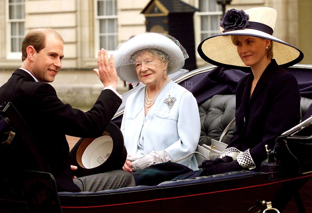 British Prince Edward waves to well-wishers as his future wife Sophie Rhys Jones and the Queen Mother look on as they travel in an open top horse-drawn carriage during Trooping the Colour ceremony in London on Saturday, 12 June 1999 (DYLAN MARTINEZ/POOL/AFP via Getty Images)