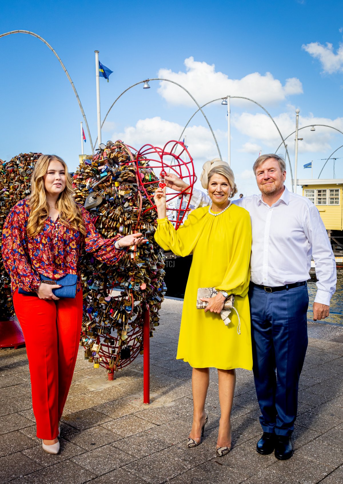 Princess Amalia of the Netherlands is seen with Queen Maxima of the Netherlands and King Willem-Alexander of the Netherlands as they celebrate their 21st wedding anniversary by hanging a key locker on the heart in front of the Pontjes bridge during the Dutch royal family's tour of the Dutch Caribbean Islands on February 2, 2023 in Willemstad, Curacao (Patrick van Katwijk/Getty Images)