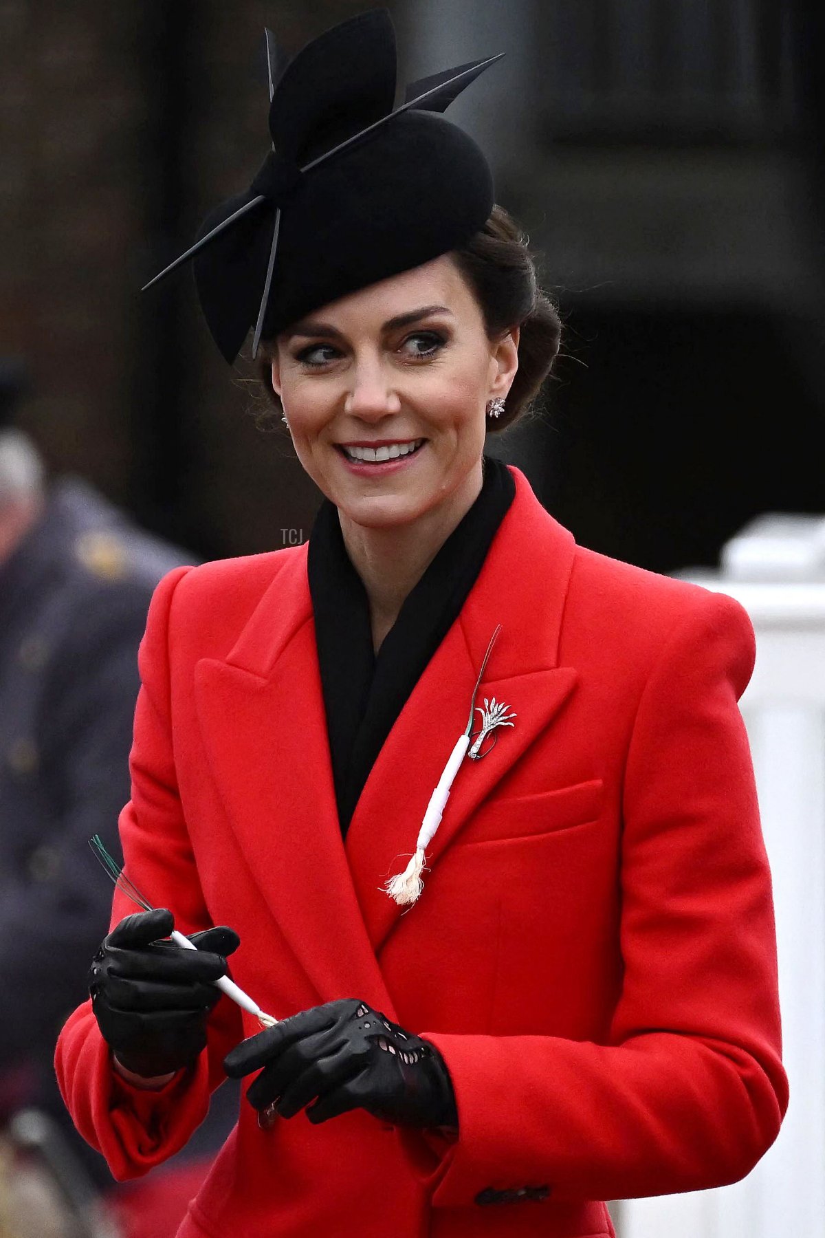 The Princess of Wales holds a leek while another is pinned on her coat during a visit to the 1st Battalion Welsh Guards for St David's Day Parade at the Combermere Barracks in Windsor, west of London, on March 1, 2023 (BEN STANSALL/AFP via Getty Images)