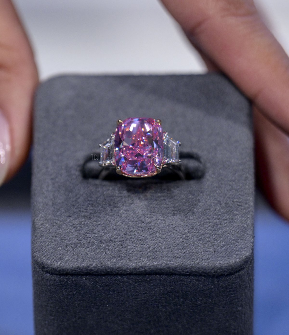 A model displays a 10.57 carat vivid pink diamond, with an estimated value of more than $35 million US dollars, during a press preview at Sotheby's in New York City on March 27, 2023 (ANGELA WEISS/AFP via Getty Images)