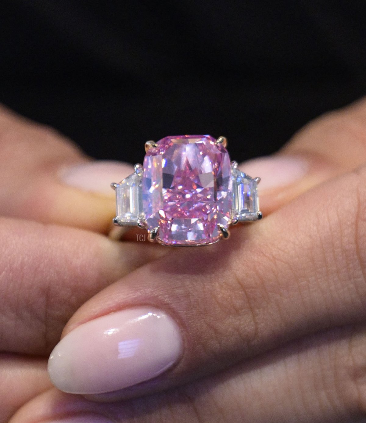 A model holds a 10.57 carat vivid pink diamond, with an estimated value of more than $35 million US dollars, during a press preview at Sotheby's in New York City on March 27, 2023 (ANGELA WEISS/AFP via Getty Images)