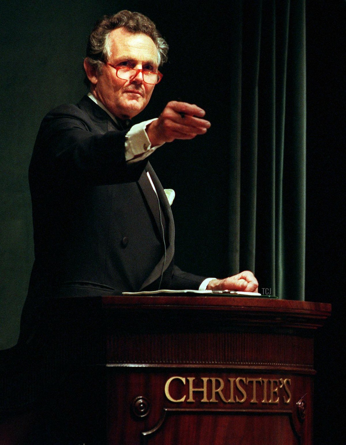 Lord Charles Hindlip, Chairman of Christie's, gestures towards bidders during the sale of dresses belonging to Diana, Princess of Wales on June 25, 1997 (JON LEVY/AFP via Getty Images)