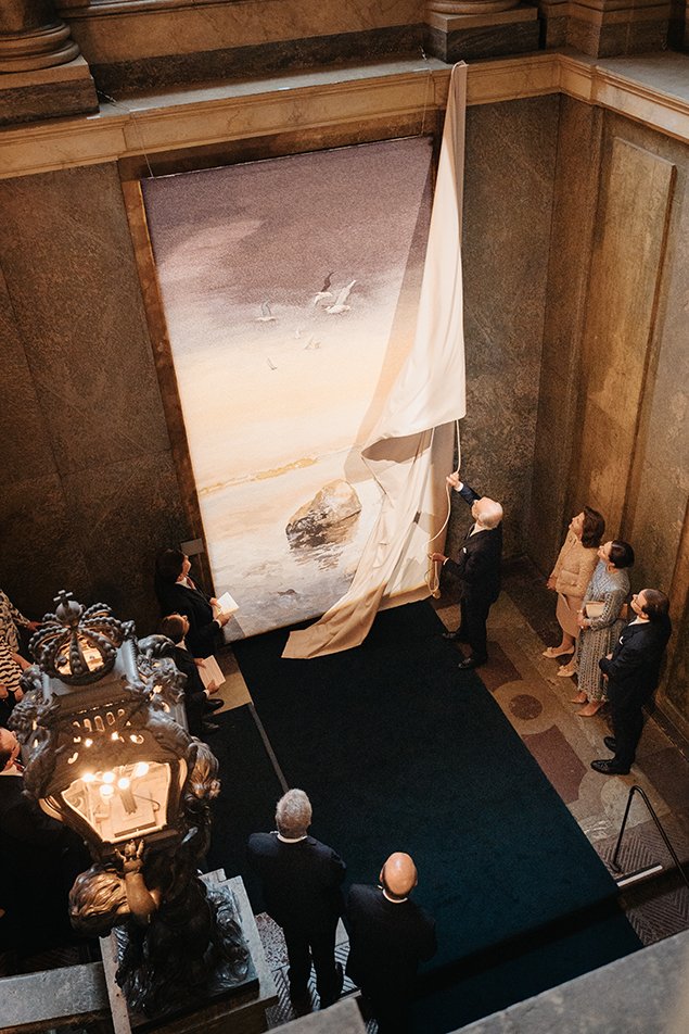 King Carl XVI Gustaf receives a tapestry, made by Alice Lund Textilier and based on a painting by Lars Lerin, from members of the Riksdag and the government at the Royal Palace in Stockholm on September 13, 2023 (Clément Morin/The Royal Palace)