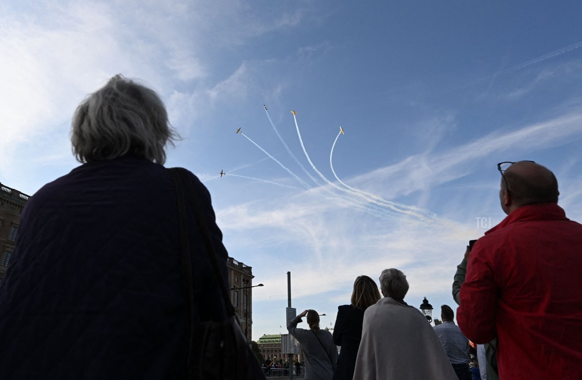 Spectators watch jet fighters flying in formation above the Royal Palace during the Golden Jubilee celebrations for King Carl XVI Gustaf of Sweden in Stockholm on September 16, 2023 (JONATHAN NACKSTRAND/AFP via Getty Images)