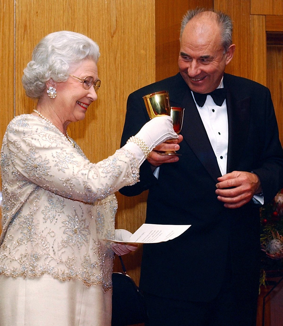 Queen Elizabeth II drinks a toast with Don McKinnon, Secretary-General of the Commonwealth, at the dinner held during the Commonwealth Heads of Government Meeting in Abuja, Nigeria on December 5, 2003 (Kirsty Wigglesworth/PA Images/Alamy)