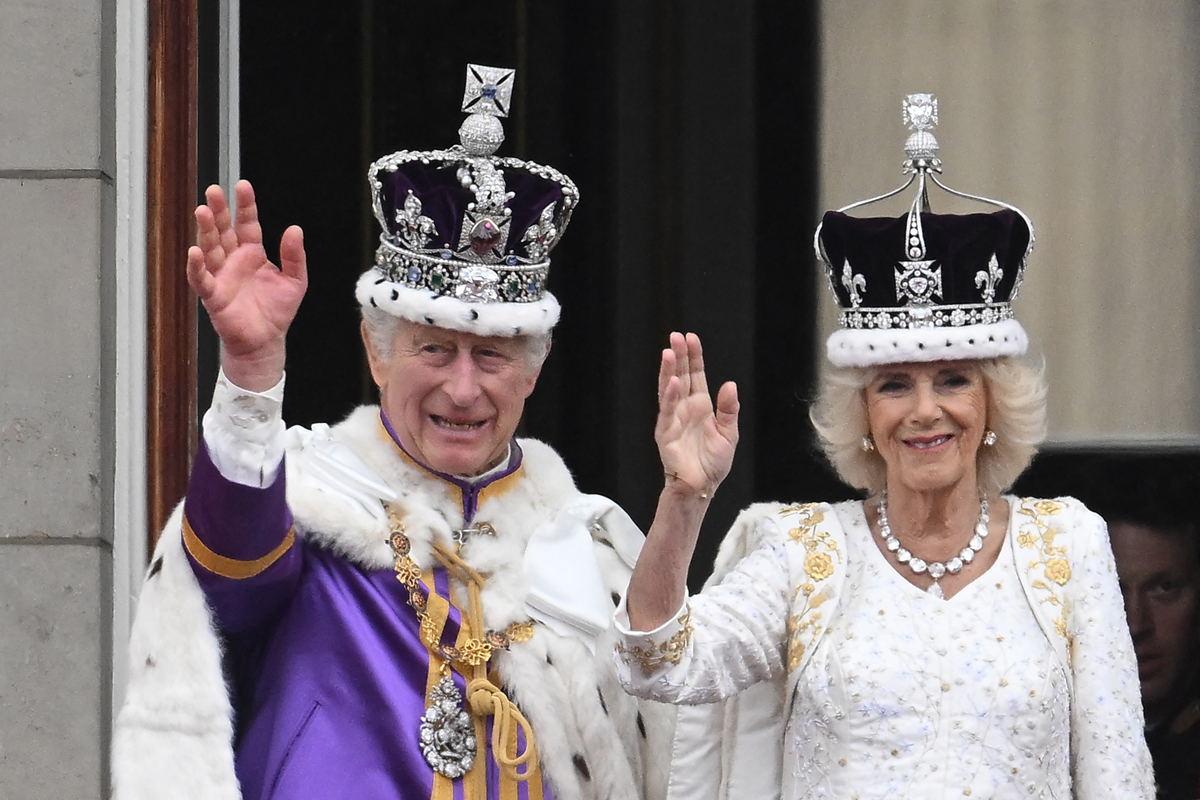 King Charles III and Queen Camilla of the United Kingdom wave from the balcony of Buckingham Palace in London after their coronation at Westminster Abbey on May 6, 2023 (MARCO BERTORELLO/AFP via Getty Images)