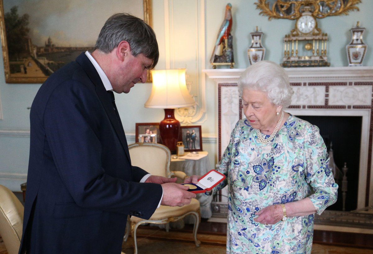 Queen Elizabeth II of the United Kingdom presents the Queen's Gold Medal for Poetry to Poet Laureate Simon Armitage at Buckingham Palace on May 29, 2019 (Jonathan Brady/PA Images/Alamy)