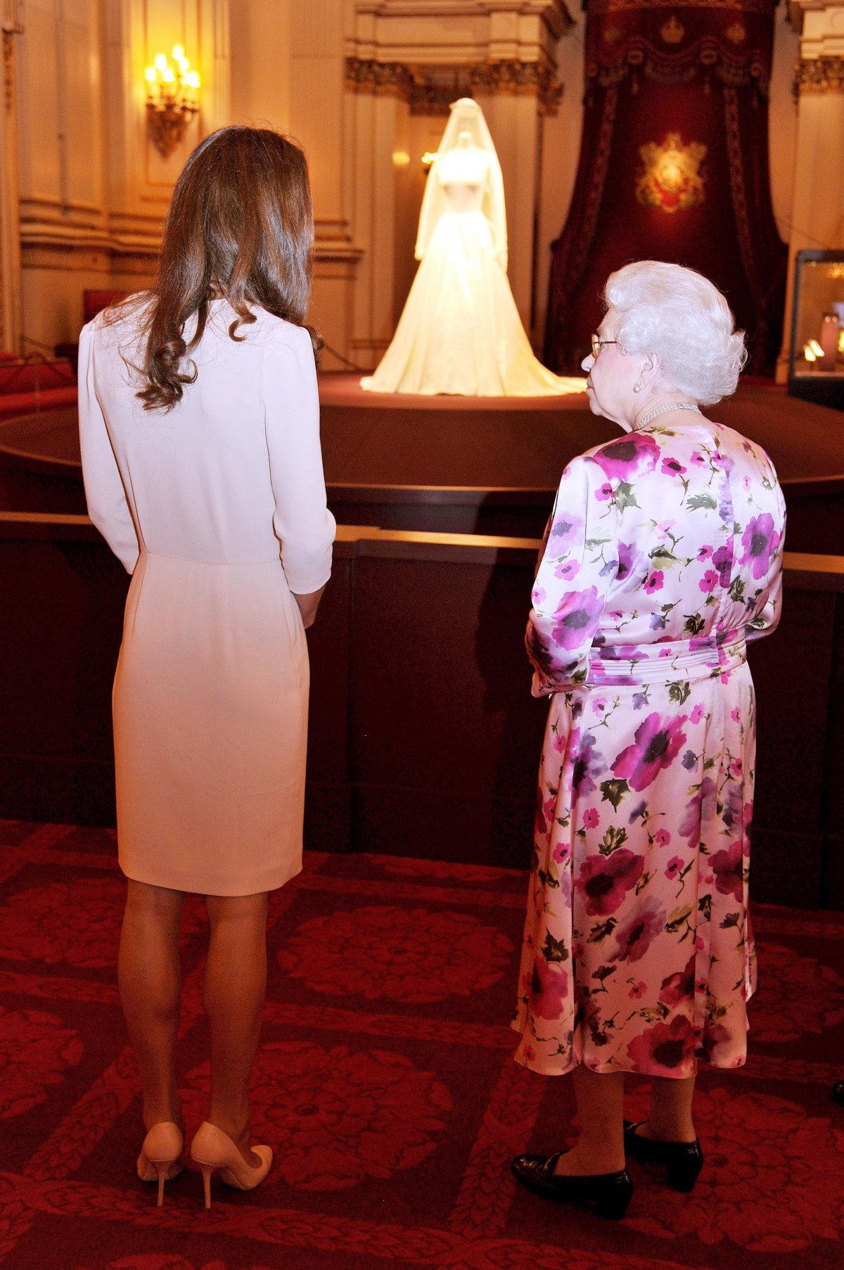The Duchess of Cambridge, accompanying Queen Elizabeth II, views her wedding dress and jewels on display at Buckingham Palace on July 22, 2011 (John Stillwell/PA Images/Alamy)