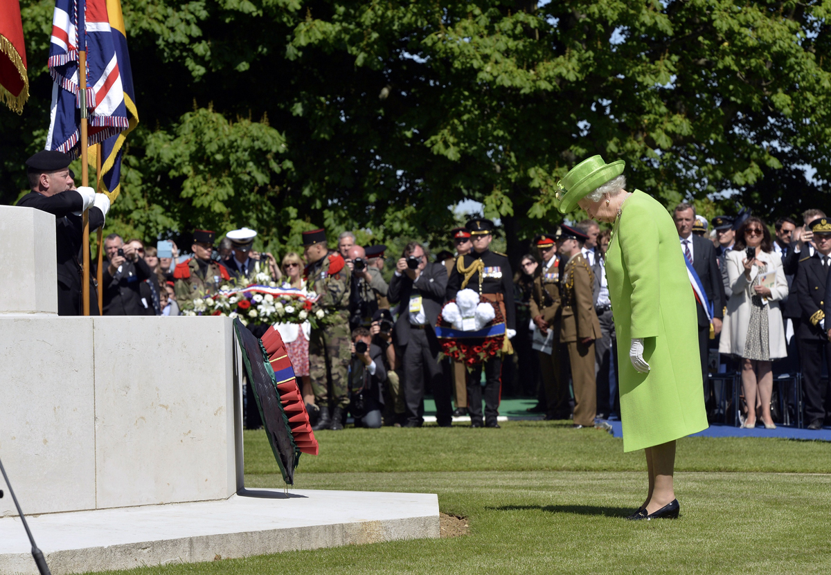 Queen Elizabeth II lays a wreath during a bi-national France-UK D-Day commemoration ceremony at the British War Cemetery in Bayeux on June 6, 2014 (TOBY MELVILLE/AFP via Getty Images)