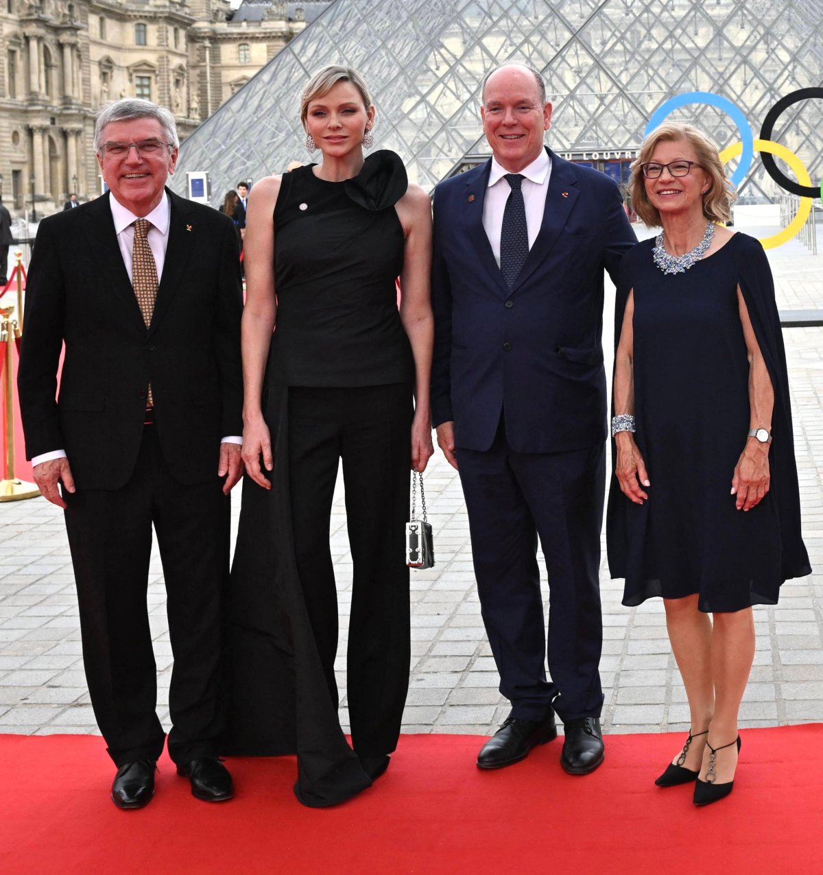 The Prince and Princess of Monaco are greeted by Thomas and Claudia Bach as they arrive for a gala dinner hosted by the International Olympic Committee and the French Presidency at the Louvre Museum in Paris on July 25, 2024 (Jeanne Accorsini/Abaca Press/Alamy)