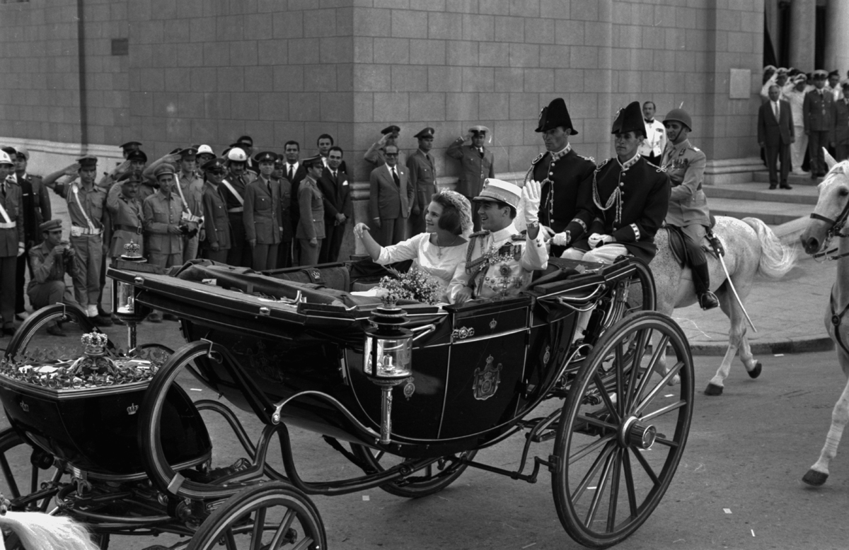 King Constantine II and Queen Anne-Marie of the Hellenes ride through the streets in a carriage on their wedding day in Athens on September 18, 1964 (Victor Blackman/Express/Getty Images)