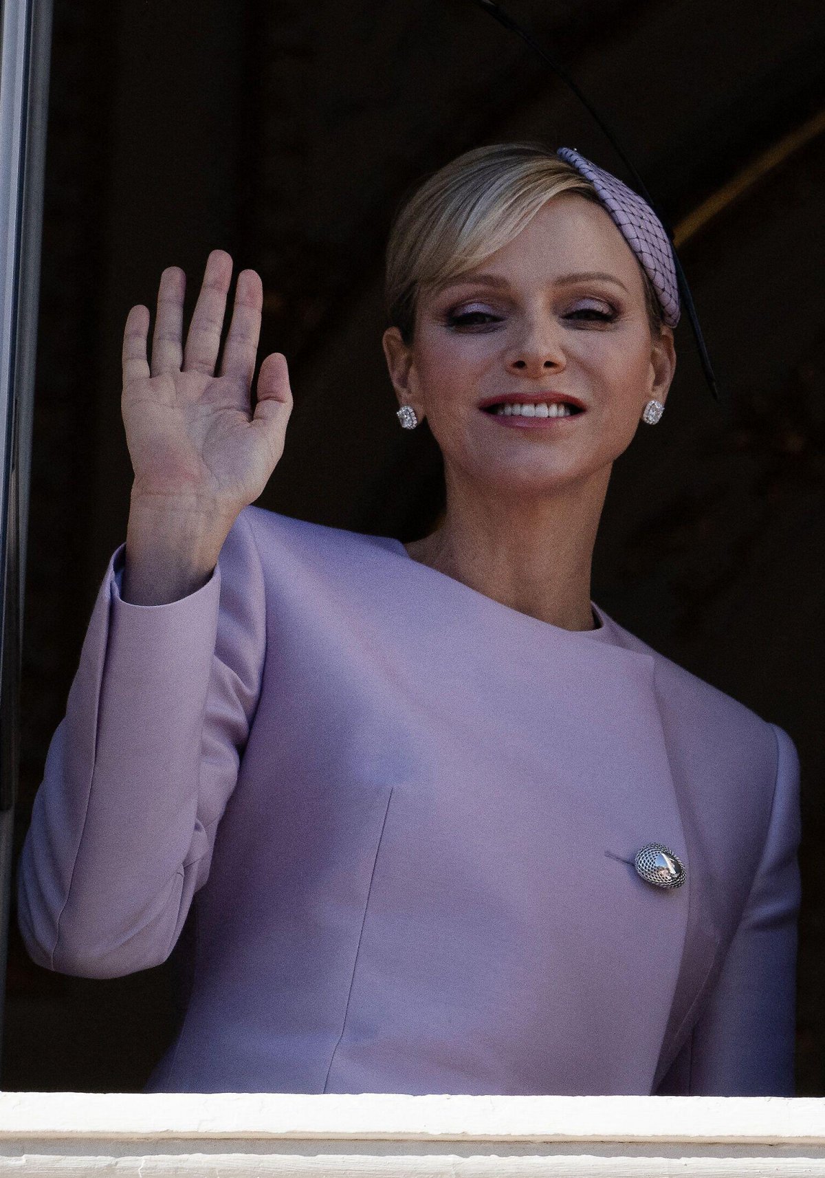 The Princess of Monaco waves to the public from a palace balcony during the celebrations of Monaco's National Day on November 19, 2024 (David Niviere/Abaca Press/Alamy)