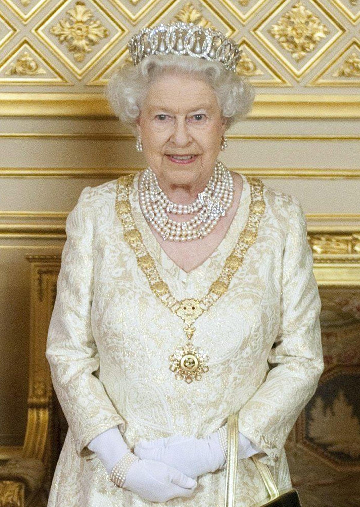 Queen Elizabeth II of the United Kingdom poses for an official photograph before a state banquet in honor of the Emir of Qatar at Windsor Castle on October 26, 2010 (KIERAN DOHERTY/PA Images/Alamy)