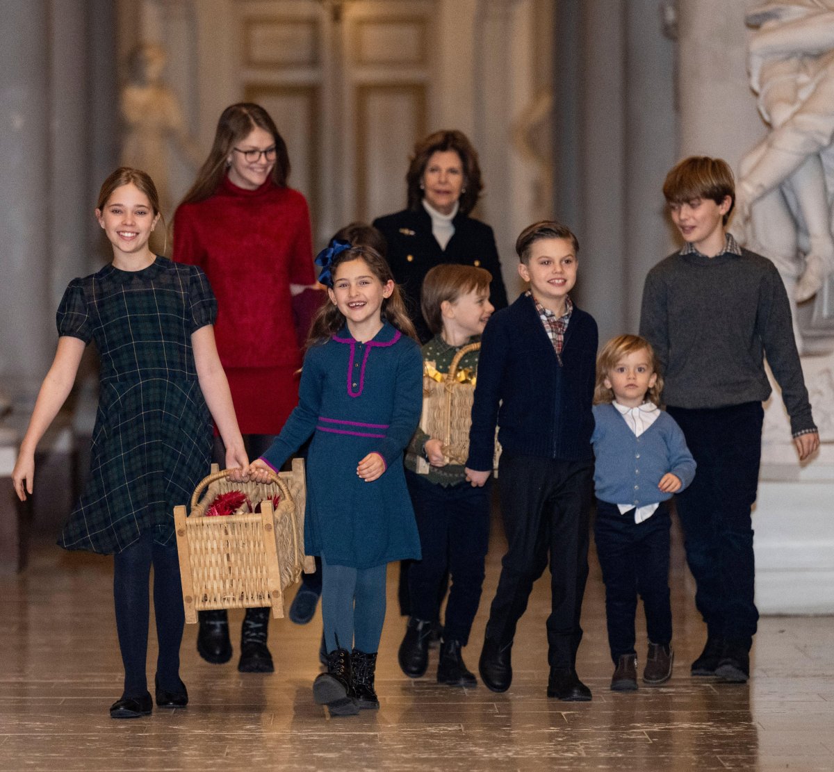 The Queen of Sweden and her grandchildren receive this year's Christmas trees at the Royal Palace in Stockholm on December 16, 2024 (Pontus Lundahl/TT News Agency/Alamy)