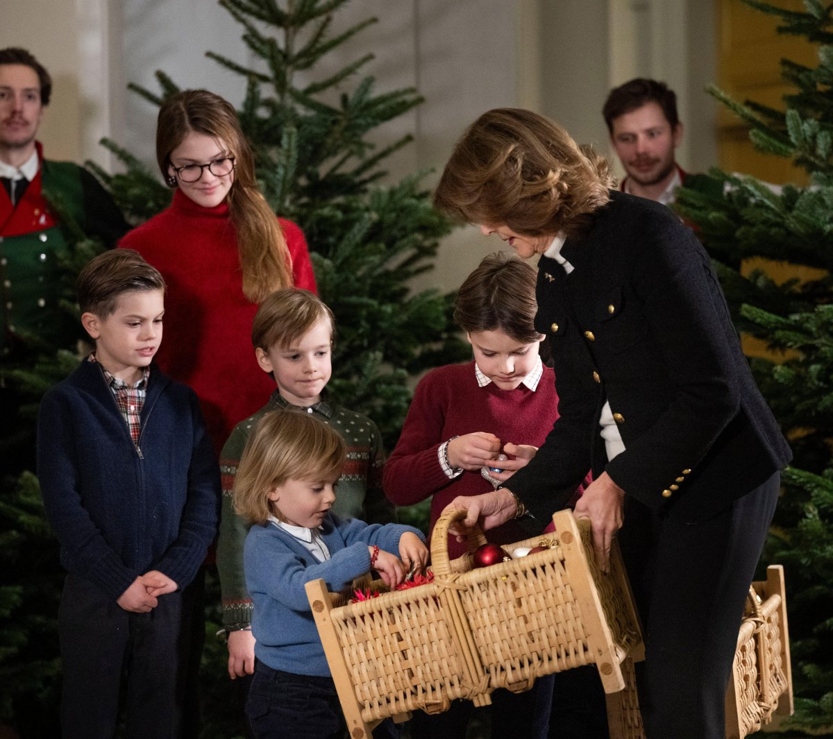The Queen of Sweden and her grandchildren receive this year's Christmas trees at the Royal Palace in Stockholm on December 16, 2024 (Pontus Lundahl/TT News Agency/Alamy)