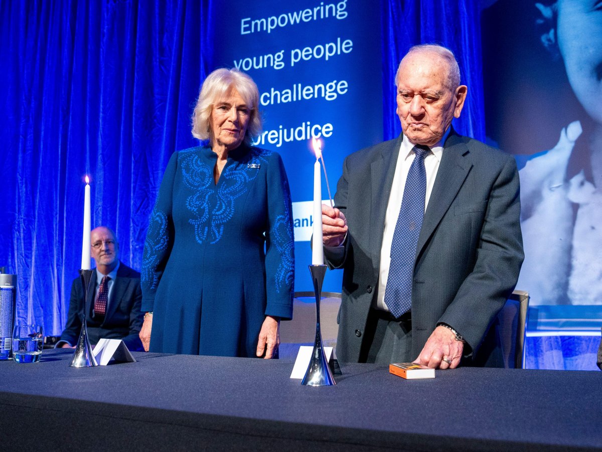 Queen Camilla watches as Holocaust survivor Arem Hersch lights a candle during a reception hosted by the Anne Frank Trust UK to mark Holocaust Memorial Day at the London Hilton, Park Lane on January 23, 2025 (Arthur Edwards/PA Images/Alamy)
