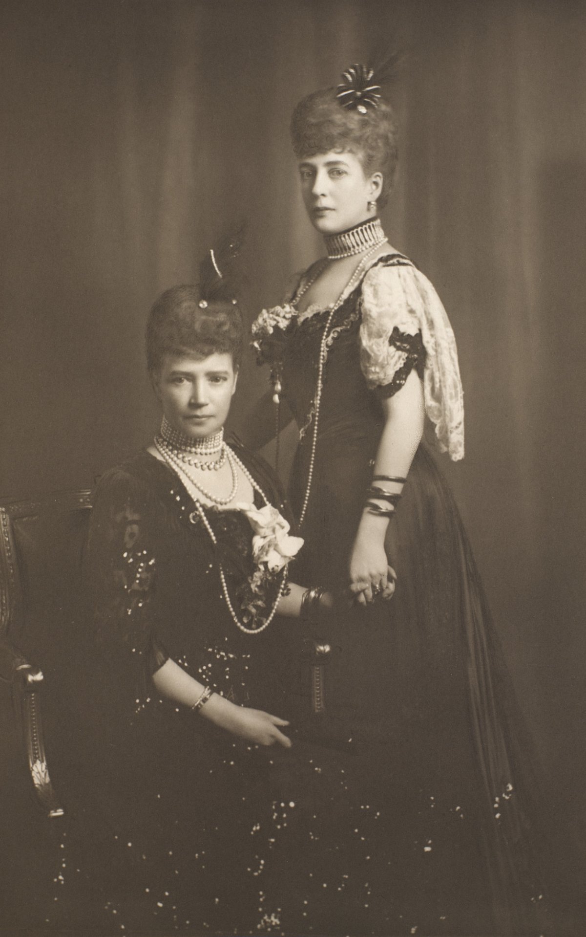Royal sisters Empress Marie Feodorovna of Russia and Queen Alexandra of the United Kingdom pose for a portrait in court dress, ca. 1907 (Royal Collection Trust)