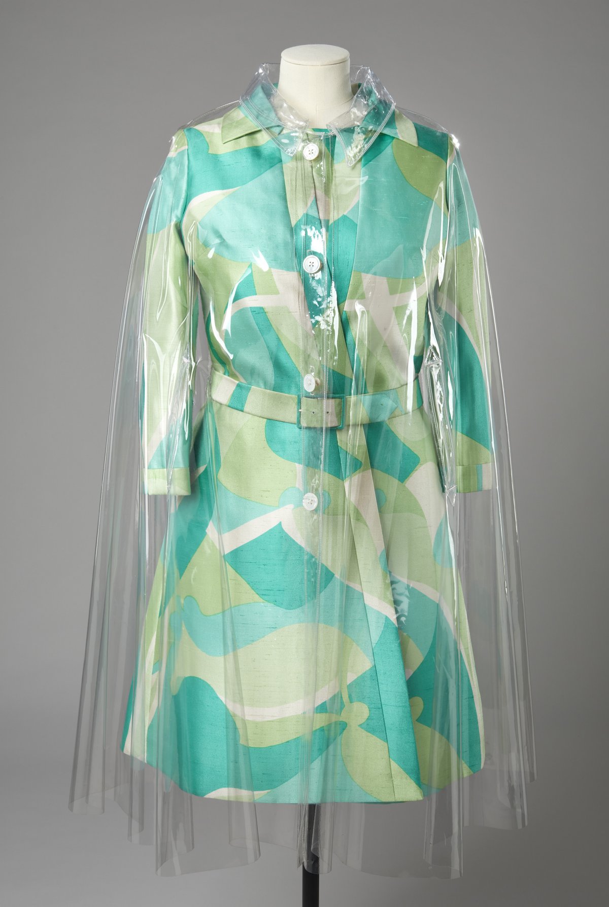 A transparent 1960s plastic raincoat, worn over a 1970s day dress, both designed by Hardy Amies for Queen Elizabeth II (Jon Stokes/Royal Collection Trust)