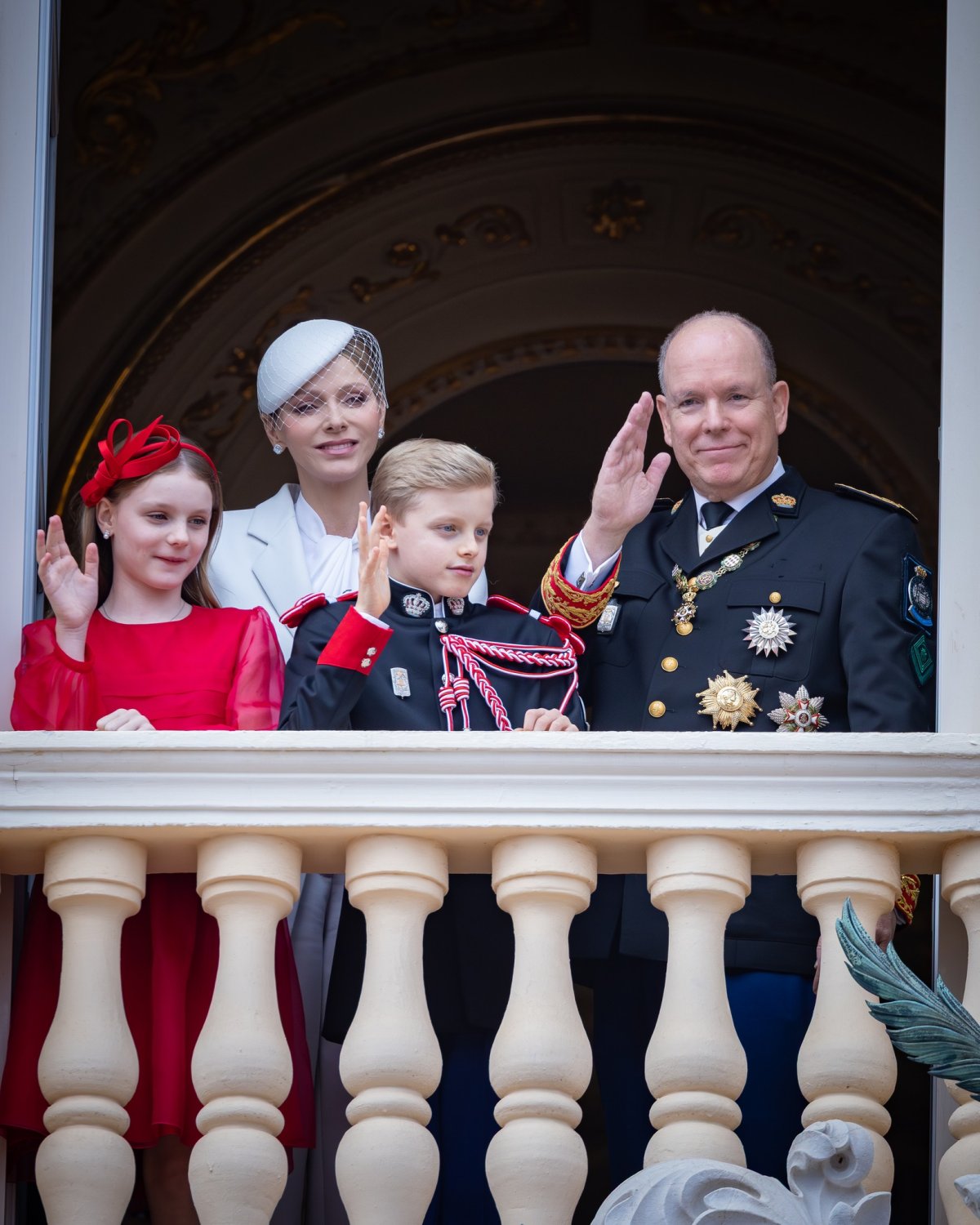 The Prince and Princess of Monaco and their children wave from the balcony of the Palais Princier during the National Day military parade on November 19, 2025 (Palais Princier de Monaco)