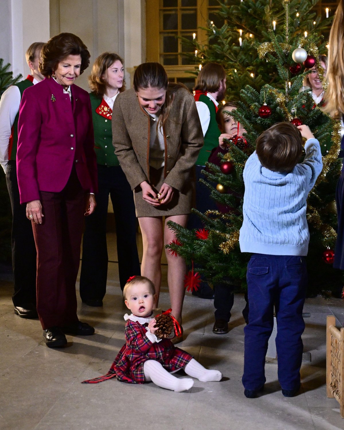 The Queen of Sweden and her grandchildren receive this year's Christmas trees at the Royal Palace in Stockholm on December 15, 2025 (Jonas Ekströmer/TT News Agency/Alamy)