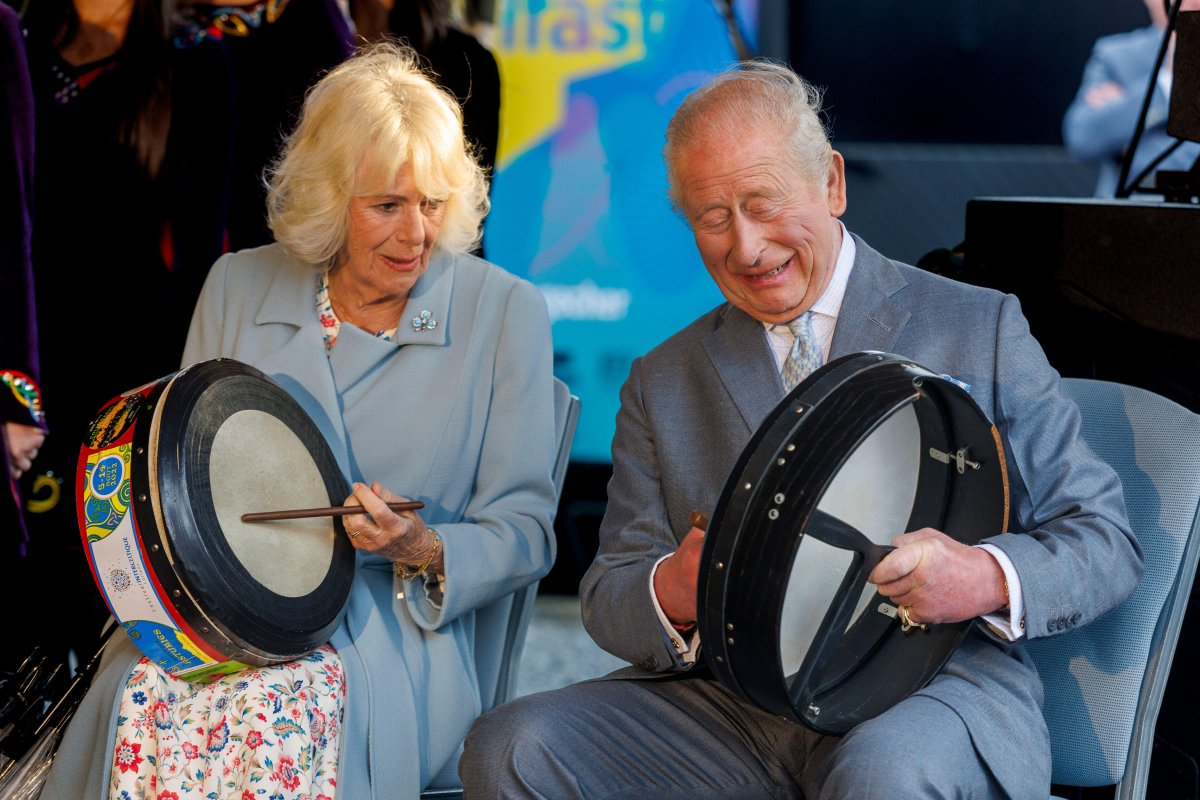 King Charles III and Queen Camilla play traditional Irish bodhran drums at Thompson Dock in Belfast on May 19, 2026 (Liam McBurney/PA Images/Alamy)