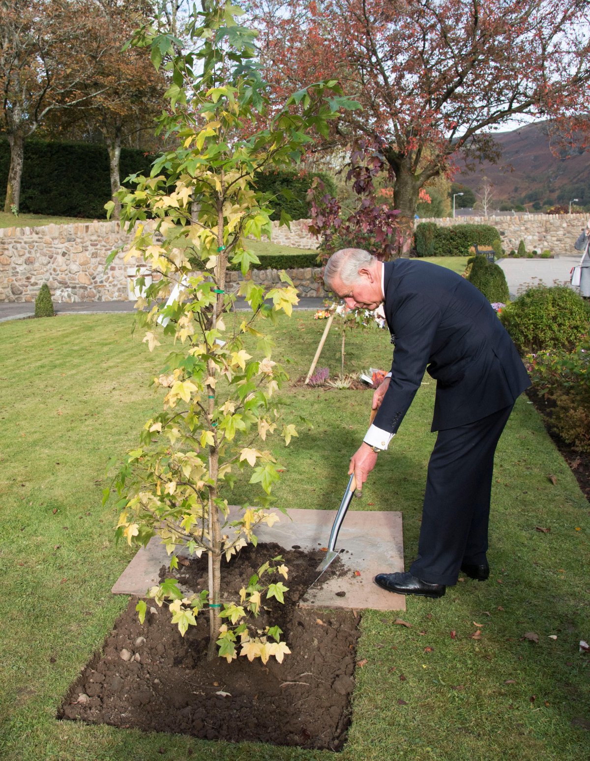 The Prince of Wales plants a tree to mark the 50th anniversary of the Aberfan disaster at the Aberfan Memorial Garden in Wales on October 21, 2016 (Arthur Edwards/PA Images/Alamy)